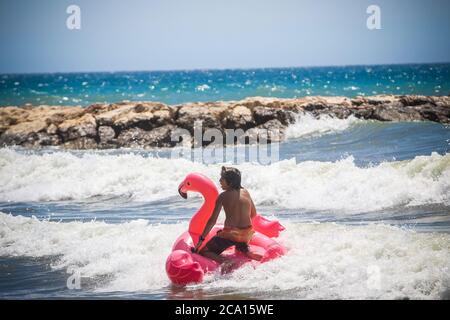 Malaga, Spanien. August 2020. An den Stränden von Pedregalejo in Malaga haben junge Leute Spaß in den Wellen des Meeres während der afrikanischen Hitzewelle im Wasser des Strandes. Kredit: Lorenzo Carnero/ZUMA Wire/Alamy Live Nachrichten Stockfoto