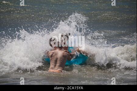 Malaga, Spanien. August 2020. An den Stränden von Pedregalejo in Malaga haben junge Leute Spaß in den Wellen des Meeres während der afrikanischen Hitzewelle im Wasser des Strandes. Kredit: Lorenzo Carnero/ZUMA Wire/Alamy Live Nachrichten Stockfoto