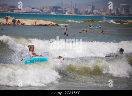 Malaga, Spanien. August 2020. An den Stränden von Pedregalejo in Malaga haben junge Leute Spaß in den Wellen des Meeres während der afrikanischen Hitzewelle im Wasser des Strandes. Kredit: Lorenzo Carnero/ZUMA Wire/Alamy Live Nachrichten Stockfoto