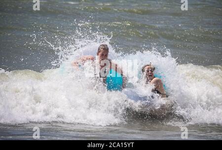 Malaga, Spanien. August 2020. An den Stränden von Pedregalejo in Malaga haben junge Leute Spaß in den Wellen des Meeres während der afrikanischen Hitzewelle im Wasser des Strandes. Kredit: Lorenzo Carnero/ZUMA Wire/Alamy Live Nachrichten Stockfoto