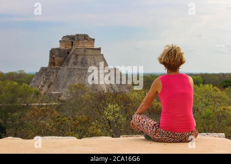 Blonde glückliche Mädchen auf ihren Urlaub in Maya-Tempel Uxmal archäologische Stätte, Mexiko. UNESCO-Weltkulturerbe. Alte Maya-Stadt und die Pyramide des Magiers in Yu Stockfoto