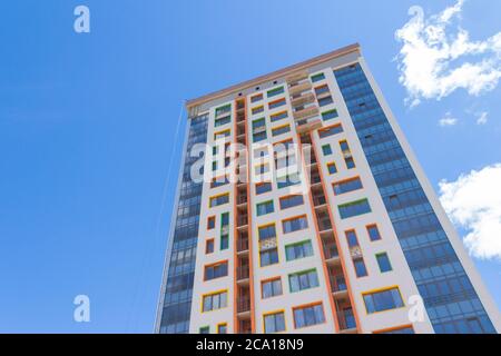 Ein Hochhaus vor blauem Himmel. Ein neues Hochhaus mit farbenfroher Fassade. Stockfoto