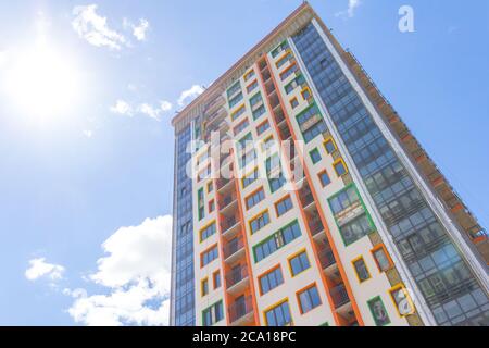 Ein Hochhaus vor blauem Himmel. Ein neues Hochhaus mit farbenfroher Fassade. Stockfoto