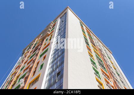 Ein Hochhaus vor blauem Himmel. Ein neues Hochhaus mit farbenfroher Fassade. Stockfoto