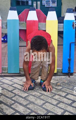 Junge Vorschule schwarzen Jungen draußen sitzen Stockfoto