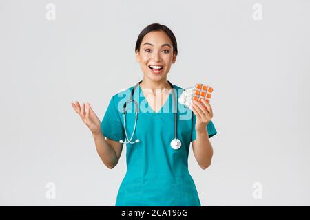 Mitarbeiter im Gesundheitswesen, Virenprävention, Quarantänekampagne Konzept. Aufgeregt glücklich asiatische Ärztin, Krankenschwester in medizinische Maske zeigt erstaunlich neu Stockfoto