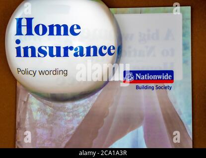 Eine Kuppellupe, die ‘Home Insurance Policy Wording’ hervorhebt - der Titel auf der Vorderseite eines Flugblatts der Nationwide Building Society. Stockfoto