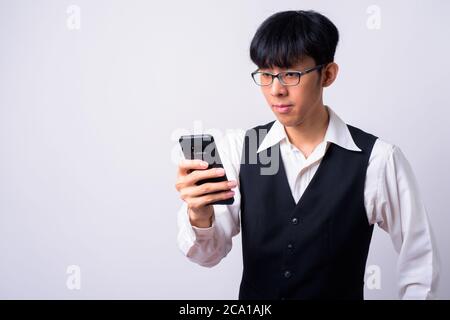 Porträt der jungen gut aussehenden Asiatische Geschäftsmann mit Mobiltelefon Stockfoto