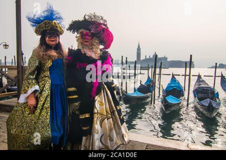 VENEDIG, ITALIEN - 28. FEBRUAR 2018: Zwei Personen mit einem typischen Kostümkleid und einer Gesichtsmaske während des Karnevals in Venedig Stockfoto