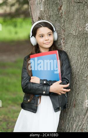Mädchen hören Audio tragen Lehrbücher entspannende Park Hintergrund, Bibliothek Playlist Konzept. Stockfoto
