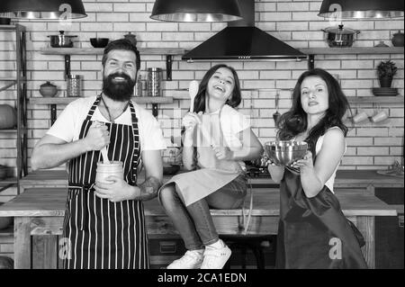 Familie Zeit. Kleines Mädchen mit Mama und Papa in der Küche. Tun Sie alles zusammen. Kochen nach Rezept. Vatertag. Verwandte Spaß beim Kochen. Mutter und Vater lehren Tochter, wie man kocht. Stockfoto