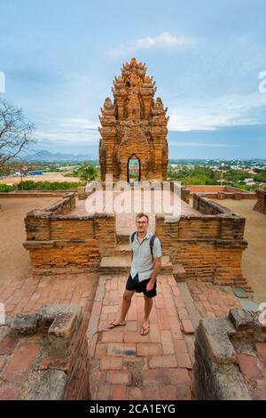 Schöner junger Mann auf dem Hintergrund der schönen Architektur Po Klong Garai Cham Tempel in Phan Rang, Vietnam. Ninh Thuan Provinz. Tempel befindet sich o Stockfoto