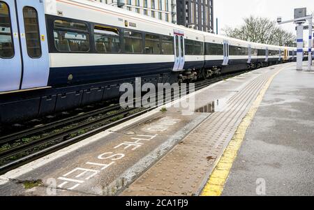 London, Vereinigtes Königreich - 01. Februar 2019: Nationaler Zug am Bahnhof Lewisham an bewölktem Tag, beachten Sie den Schritt auf dem Bahnsteig hinter gelbem l geschrieben Stockfoto