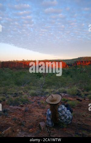 Mann, der die Morgendämmerung über dem Boodjamulla (Lawn Hill) National Park beobachtet, von der Constance Range, Outback Queensland, Australien. Nein, MR Stockfoto