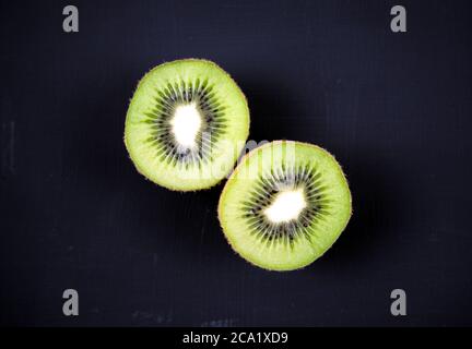 Geschnitten, geschnitten frische Kiwi Obst isoliert, Overlay auf Acryl schwarz kratzigen Grunge Malerei auf Leinwand Hintergrund. Draufsicht. Stillleben. Stockfoto