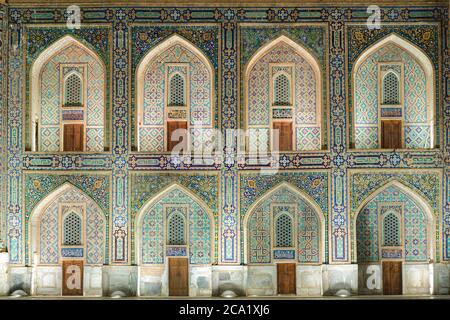 Tilya Kori Madrasah Fassade zeigt pishtaq und spandrel mit detailliertem Mosaik in der Nacht in Samarkand, Usbekistan. Islamische Architektur. Mehrere iwans. Stockfoto