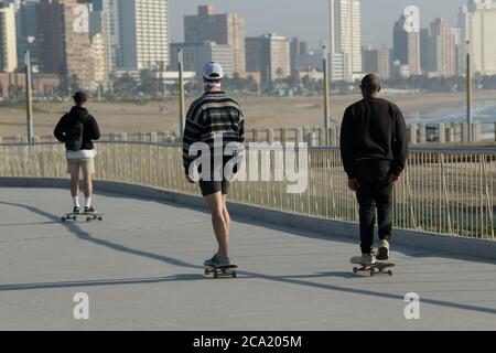 Menschen, Skateboarder, Durban, Südafrika, 3 junge Männer Reiten Skateboards am Wasser, Point Beach, Stadt, offen, Street Photography, lokal Stockfoto