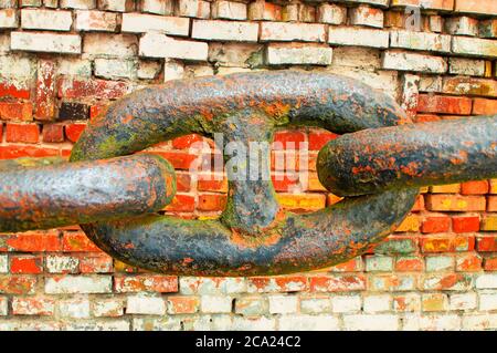 Glieder einer eisernen Kette auf einem Backstein Wand Hintergrund. Stockfoto
