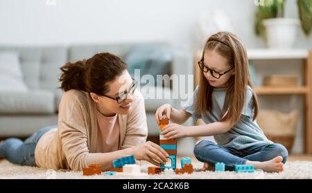 Guten Tag! Mama und ihre Tochter Kind Mädchen spielen, lächeln und umarmen. Familienurlaub und Zweisamkeit. Stockfoto