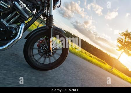 Detail des Vorderrads von High-Power-Motorrad in der Natur mit schönen Sonnenuntergang Licht. Reisen und Transport. Freiheit beim Motorradfahren Stockfoto