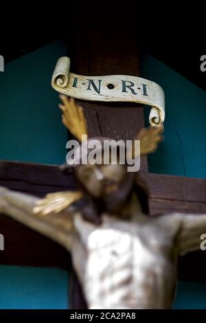 Altes Kreuz, Jesus Christus verschwommen, das Schild mit der Inschrift INRI scharf dargestellt Stockfoto