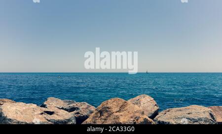 Yacht mit Segel im blauen Meer am Horizont Stockfoto