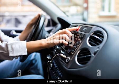 Frau drückt den Nottaster auf dem Armaturenbrett des Autos Stockfoto