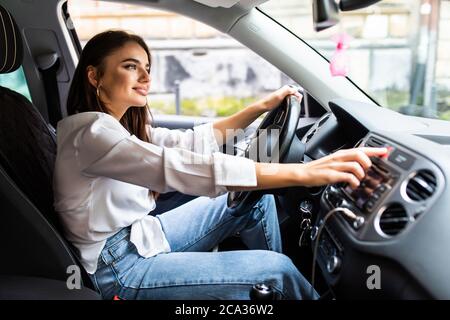 Frau drückt den Nottaster auf dem Armaturenbrett des Autos Stockfoto