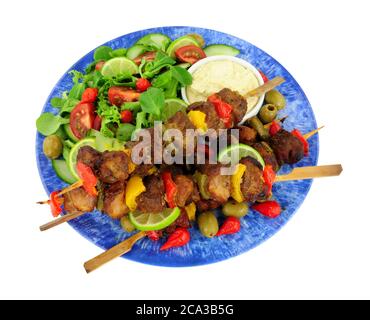 Grilled pork and sweet pepper kebabs on wooden skewers with fresh salad and mayonnaise dip isolated on a white background Stockfoto