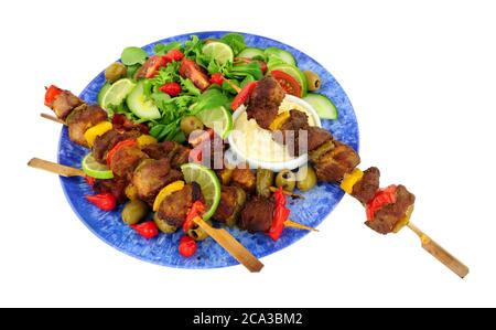 Grilled pork and sweet pepper kebabs on wooden skewers with fresh salad and mayonnaise dip isolated on a white background Stockfoto
