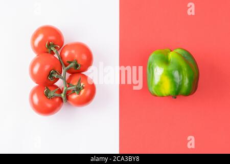 Kreatives Layout aus Pfeffer und Tomate auf farbigem rot-weißem Hintergrund. Stockfoto