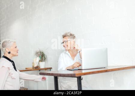 Zwei ältere Geschäftsfreunde umarmten sich nach dem Treffen im Büro Stockfoto
