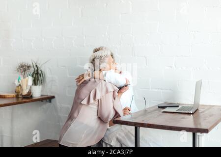 Zwei ältere Geschäftsfreunde umarmten sich nach dem Treffen im Büro Stockfoto
