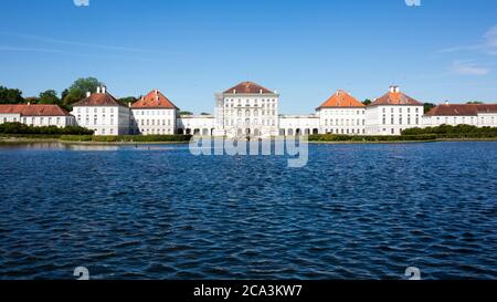 Blick auf Schloss Nyphmenburg mit Wasser im Vordergrund. Schloss Nymphenburg ist eines der Wahrzeichen Münchens. Keine Personen. Stockfoto