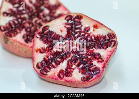 Ein geschnittener Granatapfel vor weißem Hintergrund Stockfoto