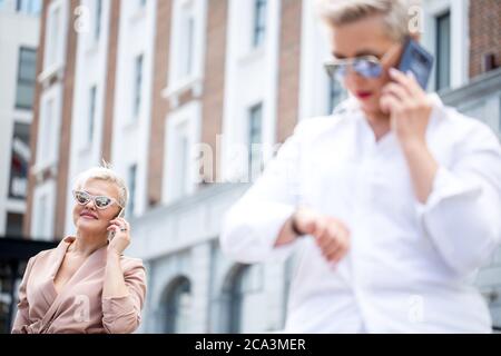 Porträt von glücklichen Geschäftsfrau suchen zuversichtlich mit verblurten weiblichen Chef auf den Vordergrund Stockfoto