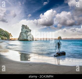 Menschen Silhouetten genießen den Blick auf Cathedral Cove Meeresschutzgebiet auf der Coromandel Halbinsel in Neuseeland in der Dämmerung. Stockfoto