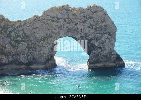 Blick auf Durdle Door mit seinem beliebten Sandstrand und ikonischem Kalksteinbogen, Lulworth Estate, Dorset, Großbritannien Stockfoto