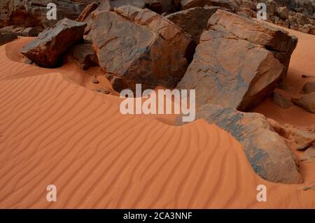 Algerien, Illizi, Tassili N'Ajjer Nationalpark: Sandmuster und Felsen im Wadi in Tehak im Tadrart Gebirge. Stockfoto