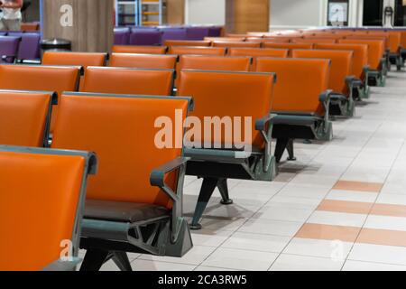 Leeres internationales Flughafengebäude während einer Pandemie. Leere Sitzreihen in der Flughafenlounge Stockfoto