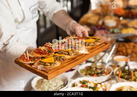 Mann, der das Essen vom Frühstückstisch im Restaurant nahm Stockfoto