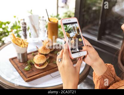 Frau, die ein Burger-Menü im Restaurant fotografiert Stockfoto