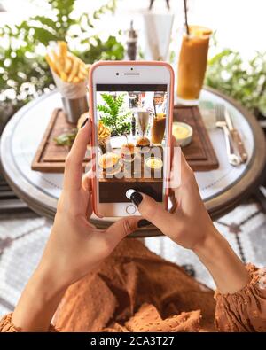 Frau, die ein Burger-Menü im Restaurant fotografiert Stockfoto