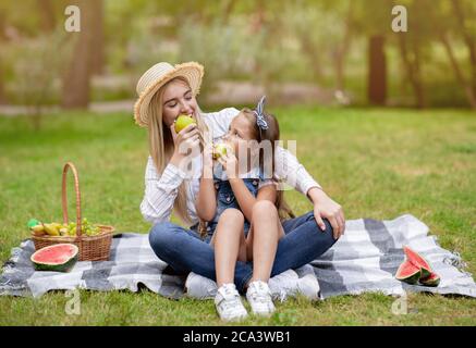 Mutter Und Tochter Auf Picknick Essen Äpfel Sitzen Im Park Stockfoto