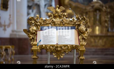 Nahaufnahme einer bibel in einer Kirche. Platziert auf einem goldfarbenen reich verzierten Rednerpult. Stockfoto