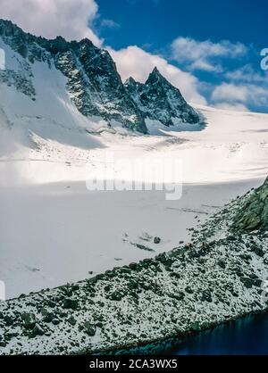 Das sind die Berge der Arolla Alpen in der Schweiz, die auf der alten Jäger-Hochgebirgshandelsroute zwischen der französischen Stadt Chamonix und der Schweizer Stadt Zermatt gesehen und überquert werden. Dies ist der Tour Gletscher und der breite Sattel, der Col du Trient an der französischen Schweizer Grenze am Rande der Aiguille d'la Tour ist, wie auf der Annäherung an die Swiss Alpine Club Besitz Cabane d' Orney neben dem Tour Gletscher gesehen. Stockfoto