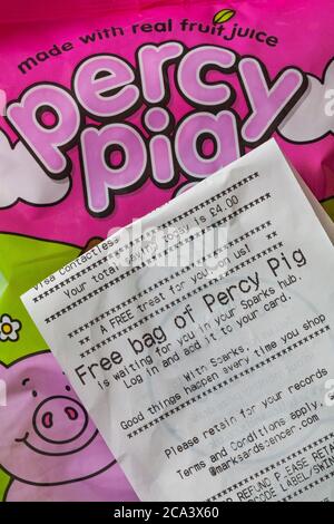 Kostenlose Tasche von Percy Pig wartet auf Sie in Ihrem Sparks Hub - Detail auf M&S Einkaufsquittung mit Packung Percy Pig Süßigkeiten mit echtem Fruchtsaft hergestellt Stockfoto