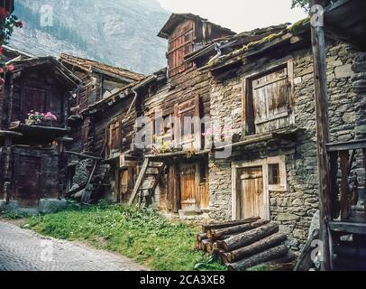 Schweiz. Zermatt. Dies ist eine Szene direkt an der Hauptstraße des Schweizer Bergurlaubsortes Zermatt, der Stadt, die mit dem ikonischen Matterhorn Berg im Schweizer Kanton Wallis verbunden ist. Diese Holzbauten sind das, was vom alten ländlichen Leben in Zermatt vor über hundert Jahren übriggeblieben ist. Stockfoto