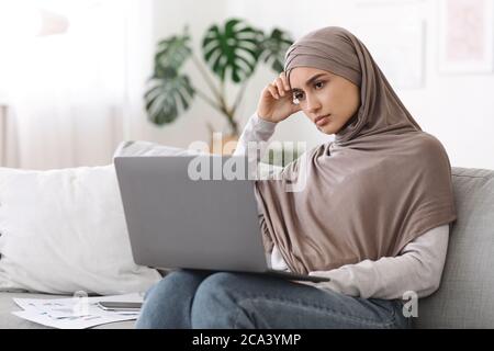 Freiberuflicher Stress. Verärgerte arabische Frau müde nach der Arbeit auf Laptop zu Hause Stockfoto