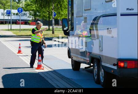 Michendorf, Deutschland. Juli 2020. Ein Polizist kontrolliert während der Verkehrssicherheitskampagne "lieber sicher. Lieber live.' auf dem Gelände der Raststätte Michendorf-Nord. Unter anderem wurde das Gewicht des Fahrzeugs gemessen, das aufgrund von Gepäck und anderer Last zu hoch sein könnte. Quelle: Soeren Stache/dpa-Zentralbild/ZB/dpa/Alamy Live News Stockfoto